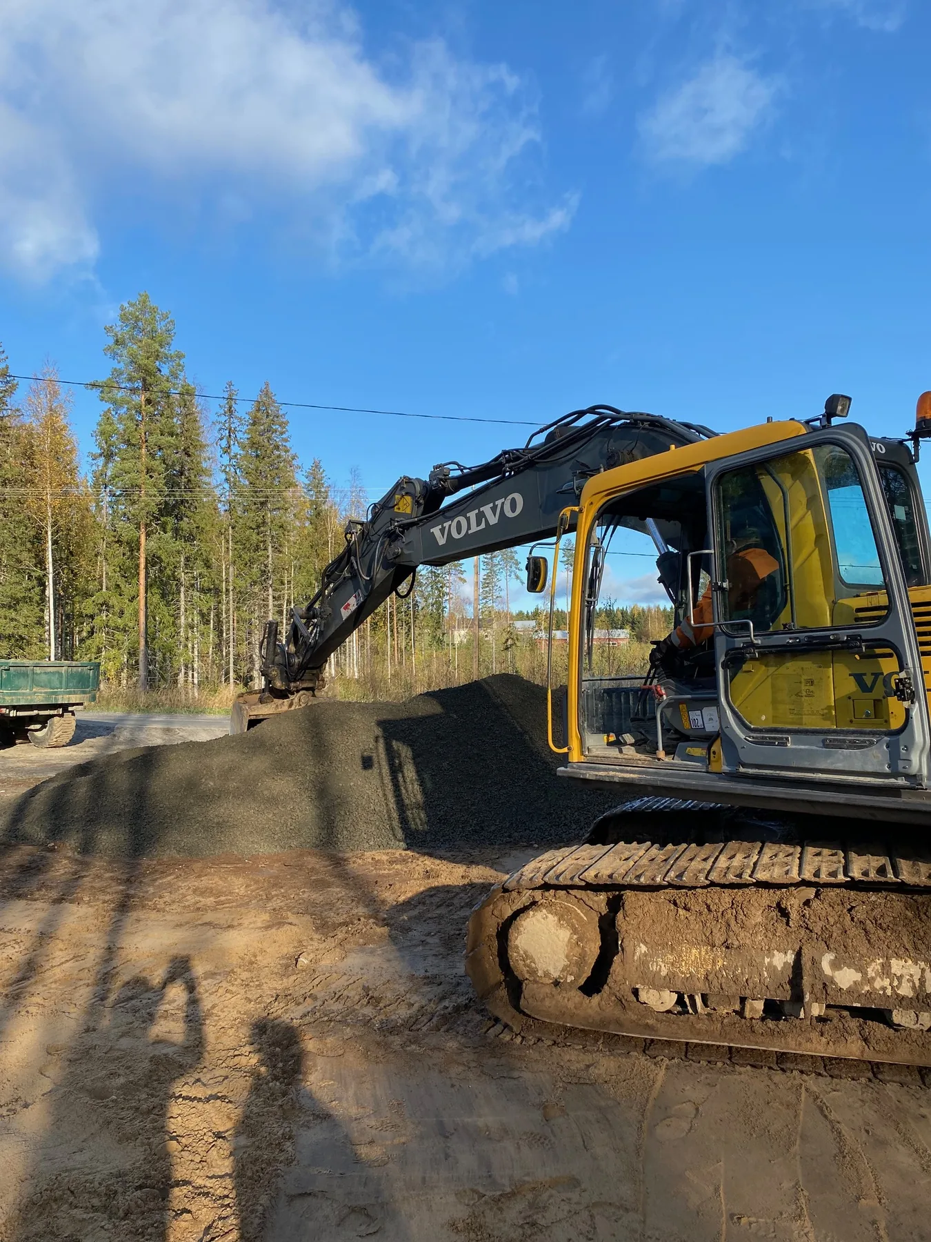 Kaivuri aloittamassa kylätalon rakennustöitä